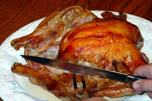 Cut through the skin between leg and the body of the turkey